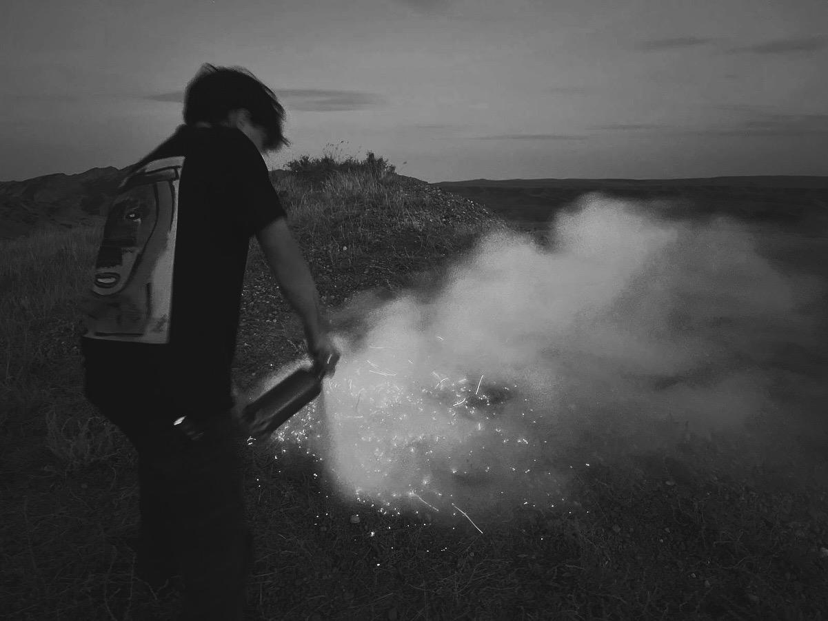Two crew members setting up lighting in a white studio